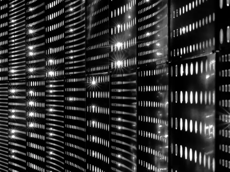 Façade de serveurs en rack dans un datacenter, voyants allumés.